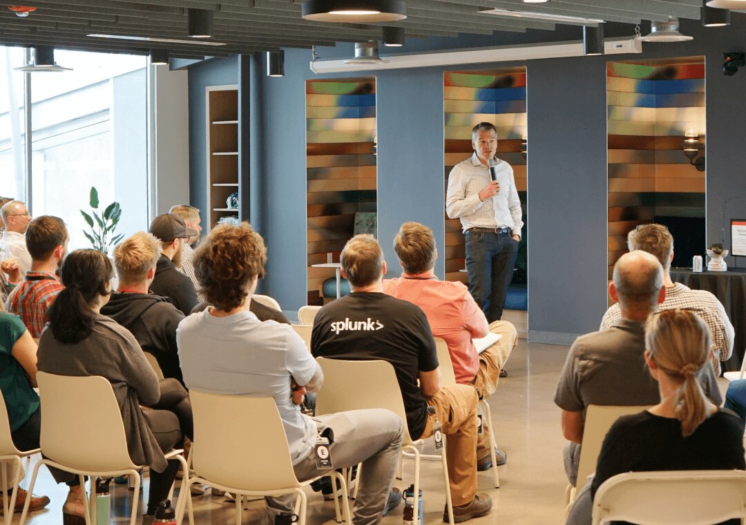 An executive hosts a professional development session with an audience of Splunkers.