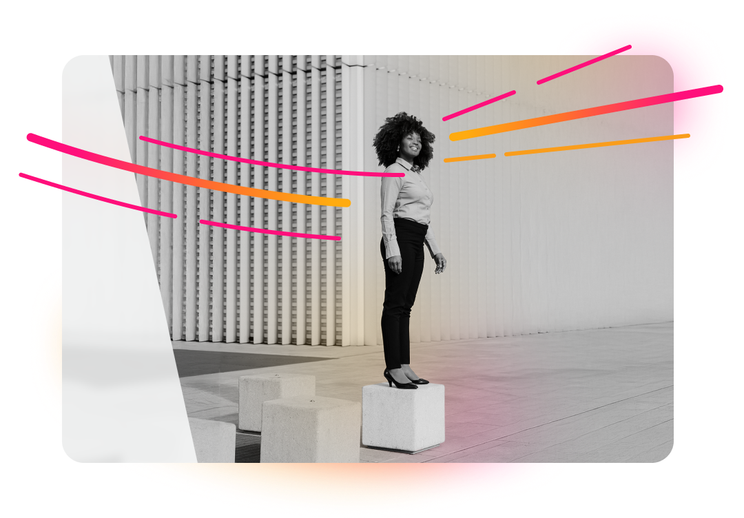 A smiling woman with curly hair stands on a white block in front of a modern building, with abstract pink and orange lines overlaid on the image.