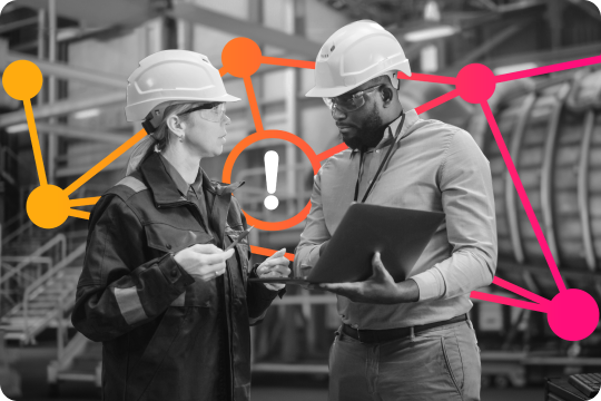 two individuals in hard hats at a manufacturing plant
