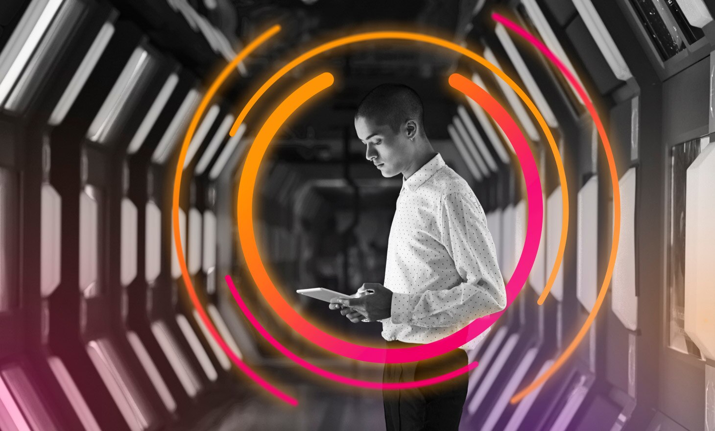 A man looks down at a tablet e-reader. He is ringed with rays of pink and orange light.
